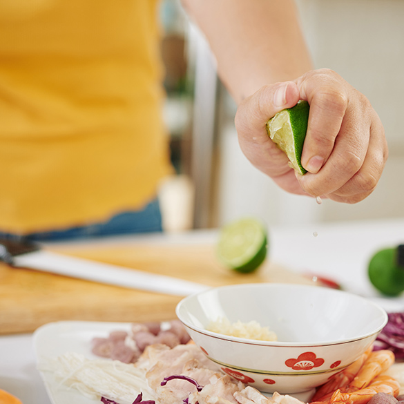 Junge Frau die Saucen für Fleischfondue zubereitet.