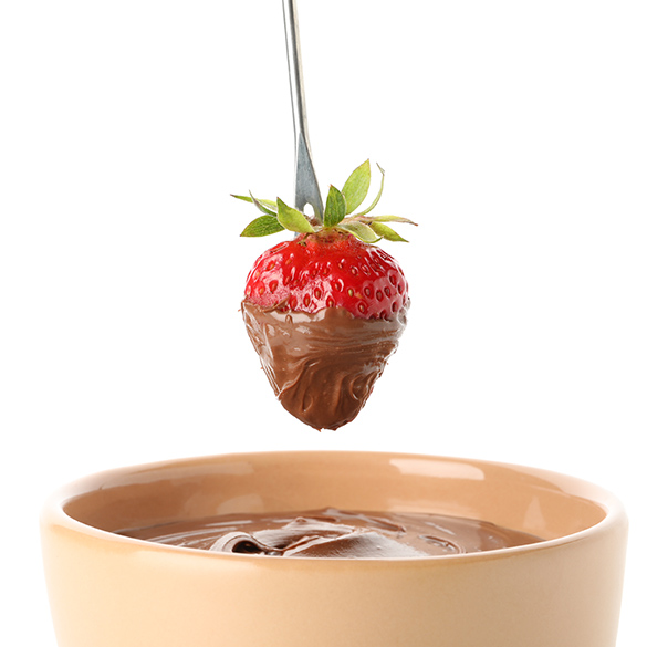 Ein kleines Schokofondue in der Tasse mit einer Erdbeere.
