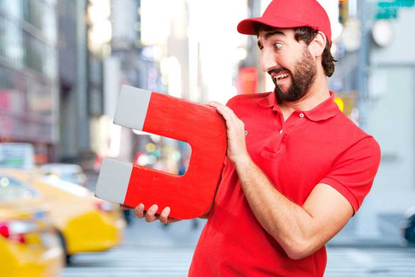 Mann hält einen großen Magnet in der Hand.